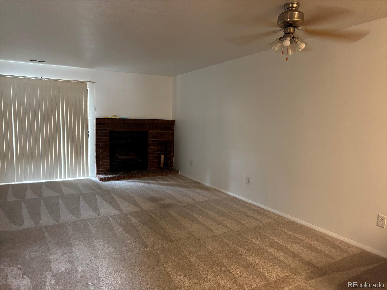 2275 South Buckley Road, Unit 101 Aurora, CO 80013 - Photo 4 of 14 an empty room with a ceiling fan and window