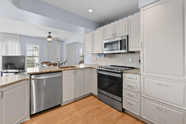 a kitchen with white cabinets stainless steel appliances and sink