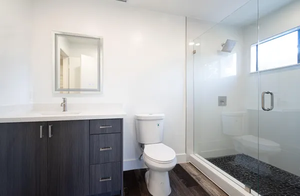 a bathroom with a sink a toilet and shower