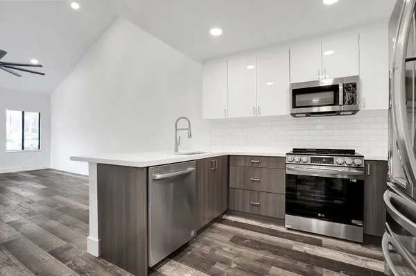 a kitchen with stainless steel appliances granite countertop a stove and a microwave