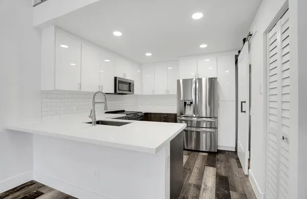 a kitchen with stainless steel appliances a refrigerator sink and microwave