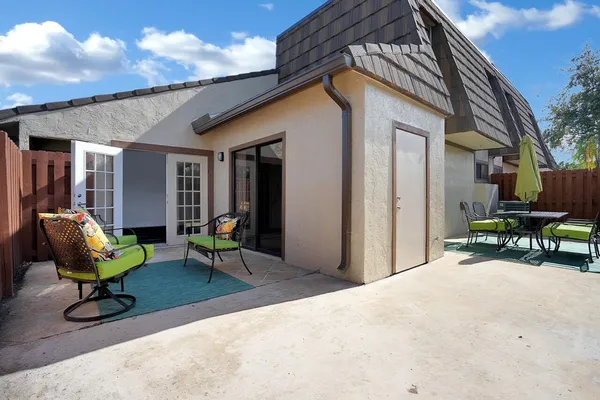 a view of a house with backyard and sitting area