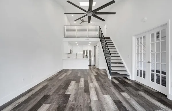 a view of a hallway with wooden floor and staircase