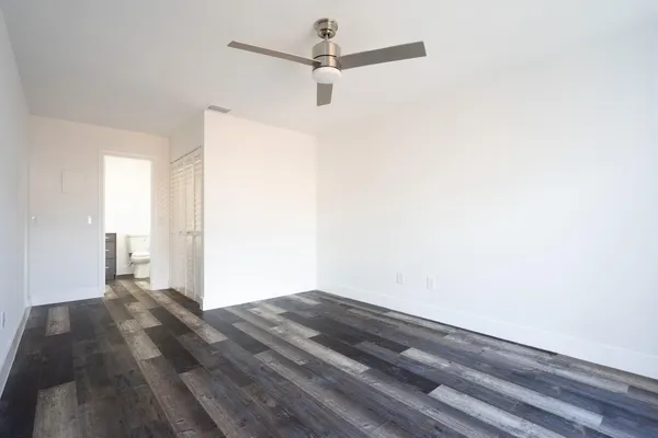 a view of a room with wooden floor and a ceiling fan