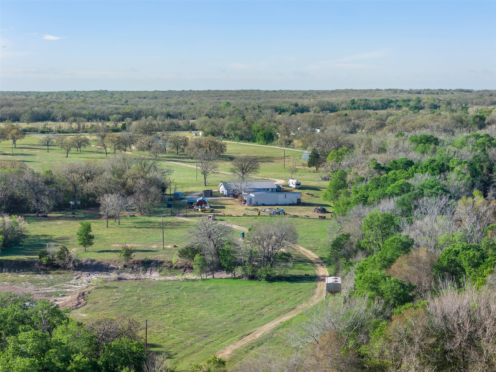 Expansive property featuring a mix of open grassy areas and dense mature trees, offering a secluded environment