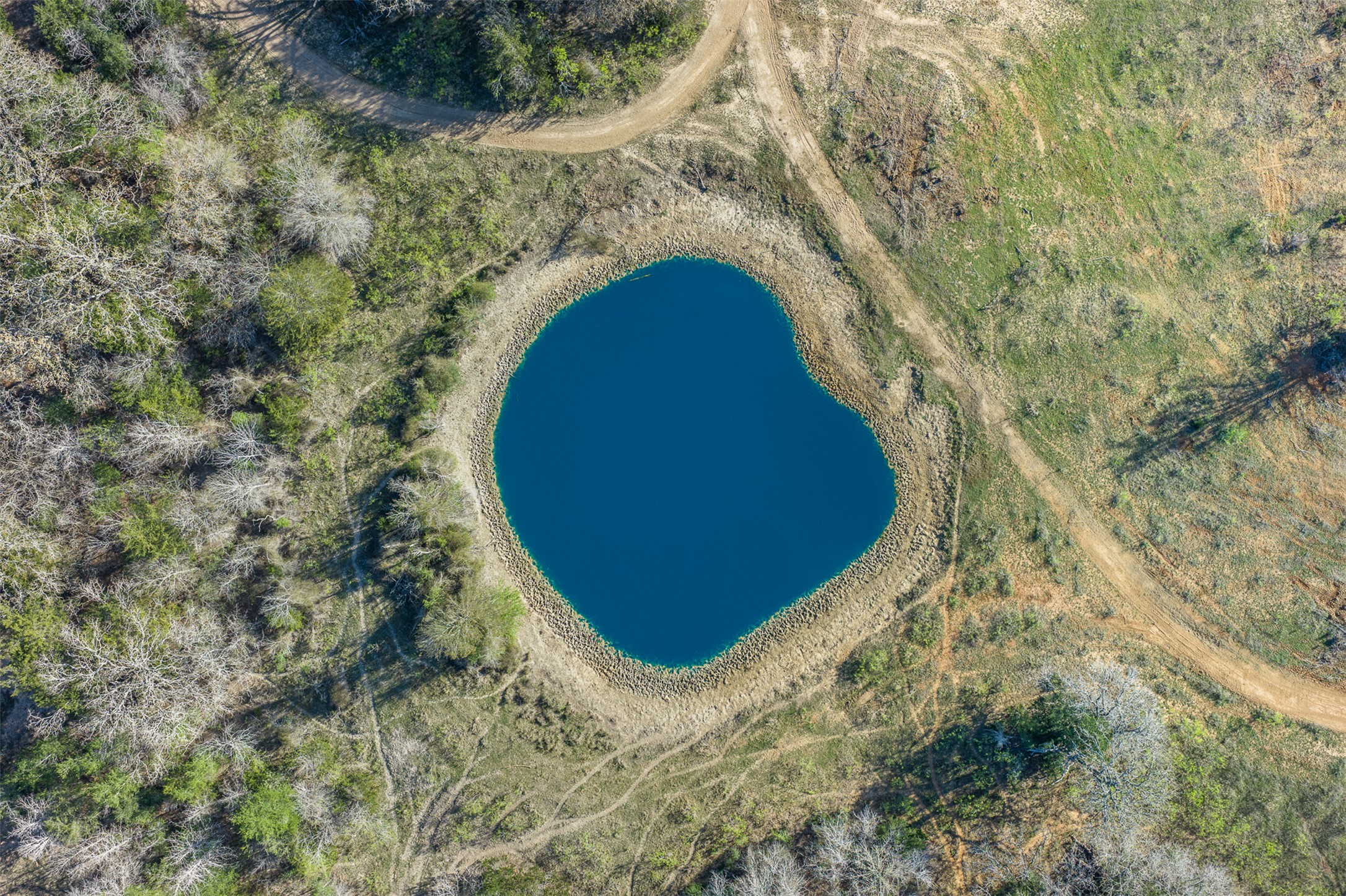 2313 Highway 79 Milano, TX 76556 - Photo 15 of 40 Natural body of water surrounded by varied terrain, featuring wooded areas, open grassy spaces, and visible pathways