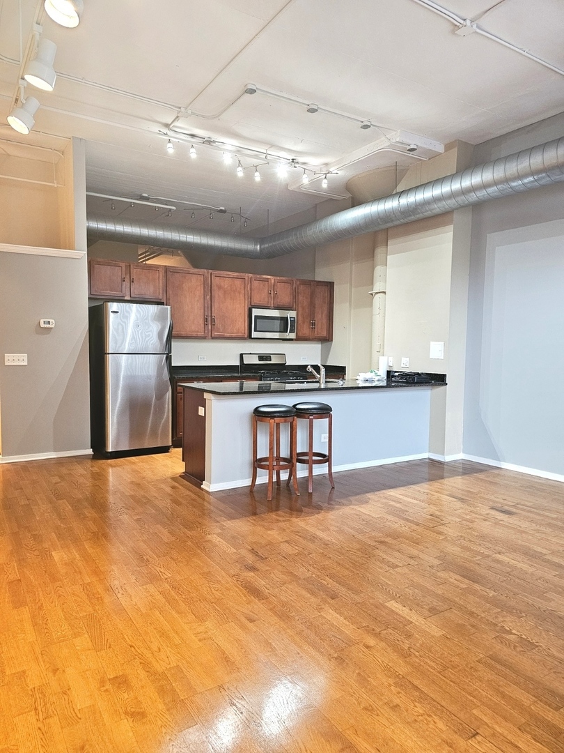 2323 West Pershing Road, Unit 128 Chicago, IL 60609 - Photo 5 of 9 a kitchen with stainless steel appliances granite countertop a stove and a refrigerator