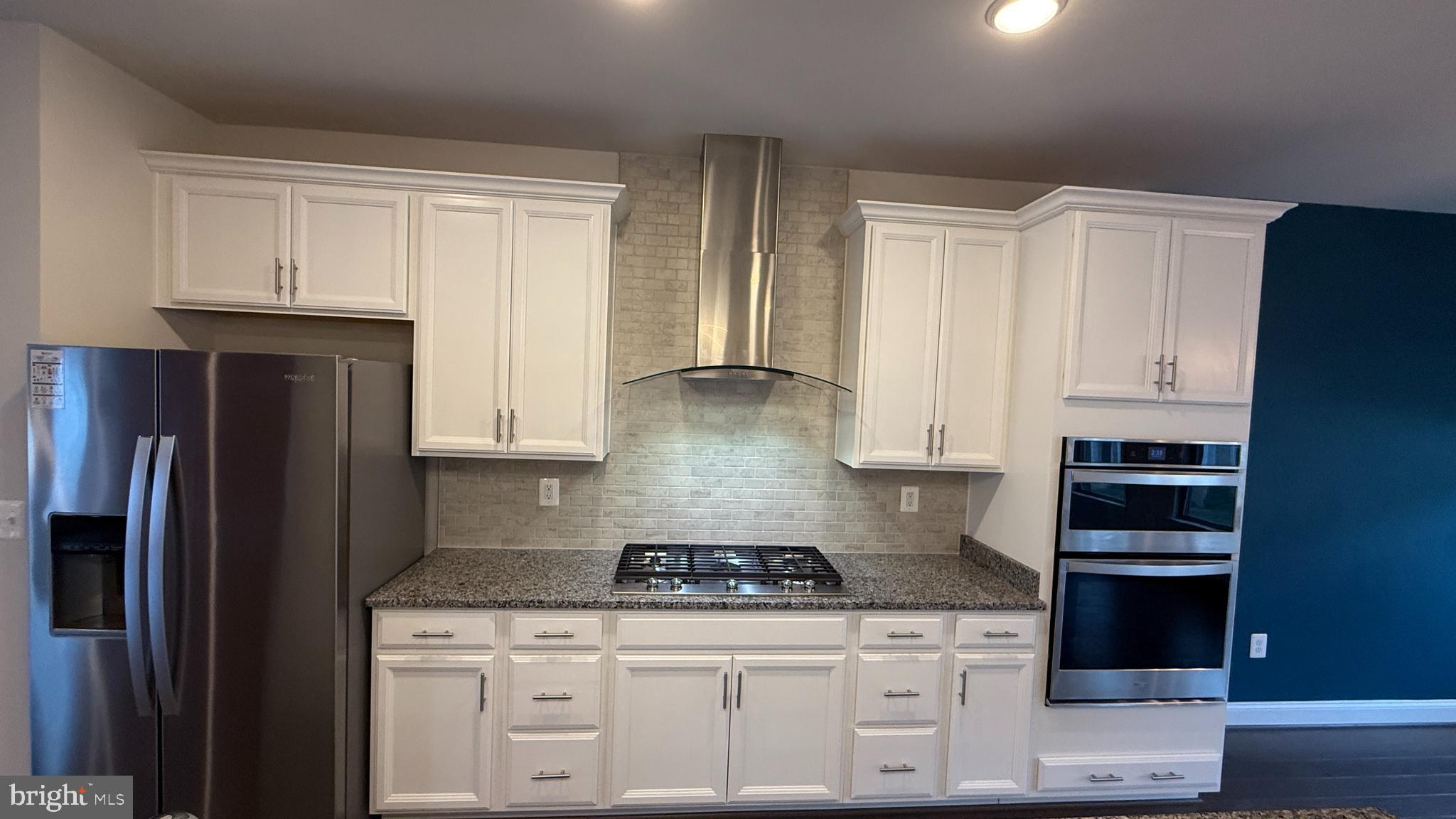 1949 Greenbriar Hall Road Dumfries, VA 22026 - Photo 5 of 26 a kitchen with granite countertop white cabinets and stainless steel appliances