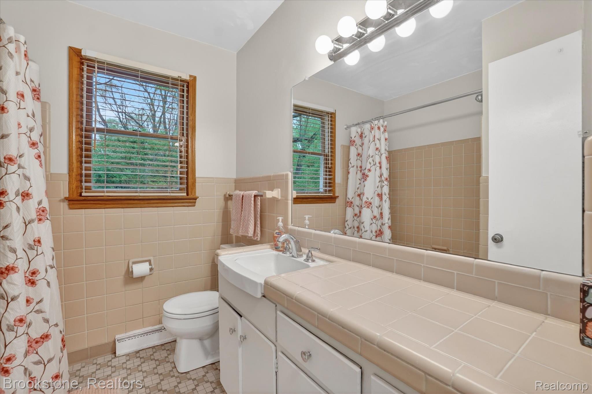 4547 Marlborough Road Okemos, MI 48864 - Photo 16 of 55 Bathroom with vanity, baseboard heating, a shower with curtain, tile walls, and light tile patterned flooring