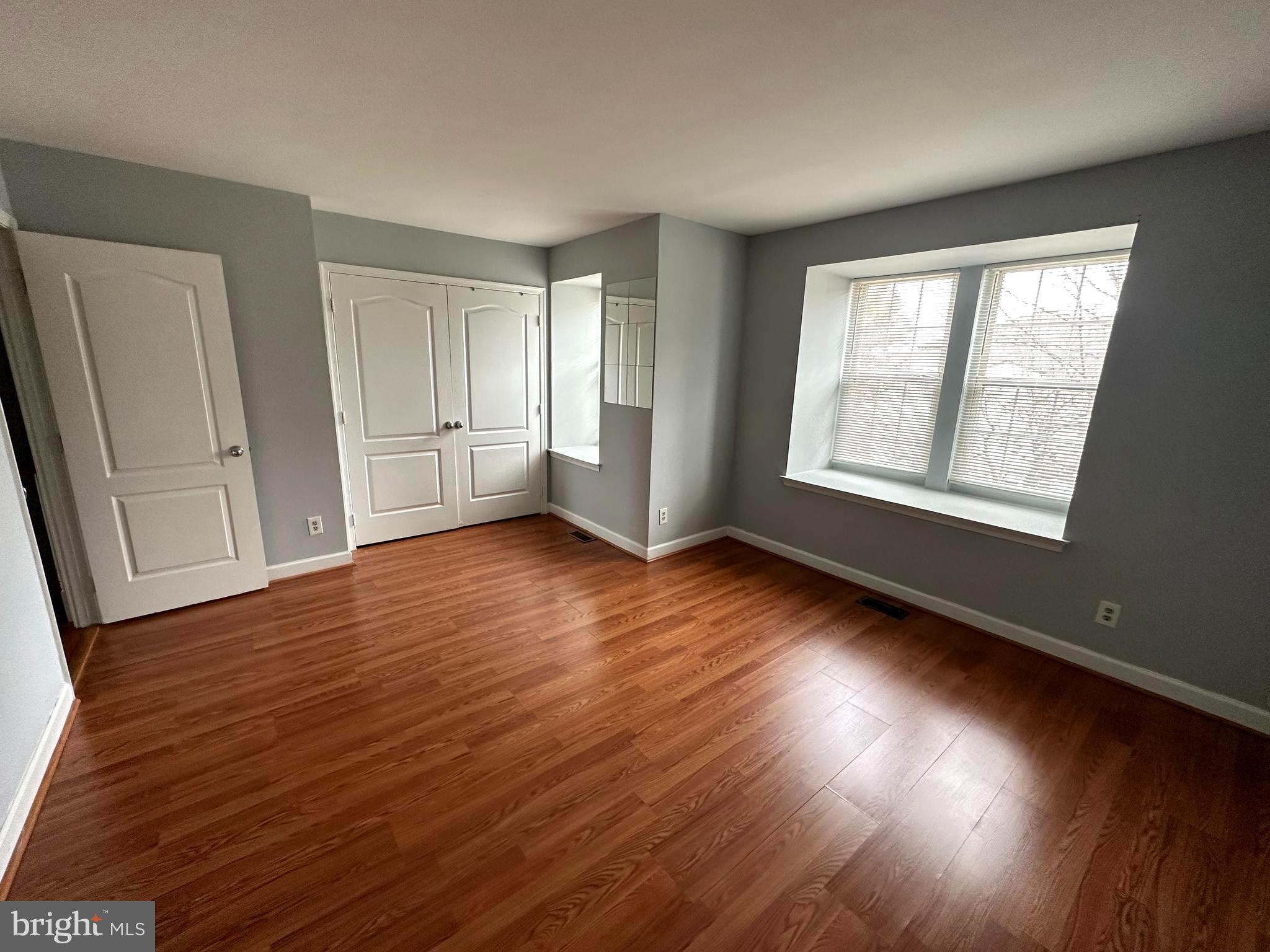 4033 Chesterwood Drive, Unit 4033 Silver Spring, MD 20906 - Photo 11 of 13 an empty room with wooden floor and windows