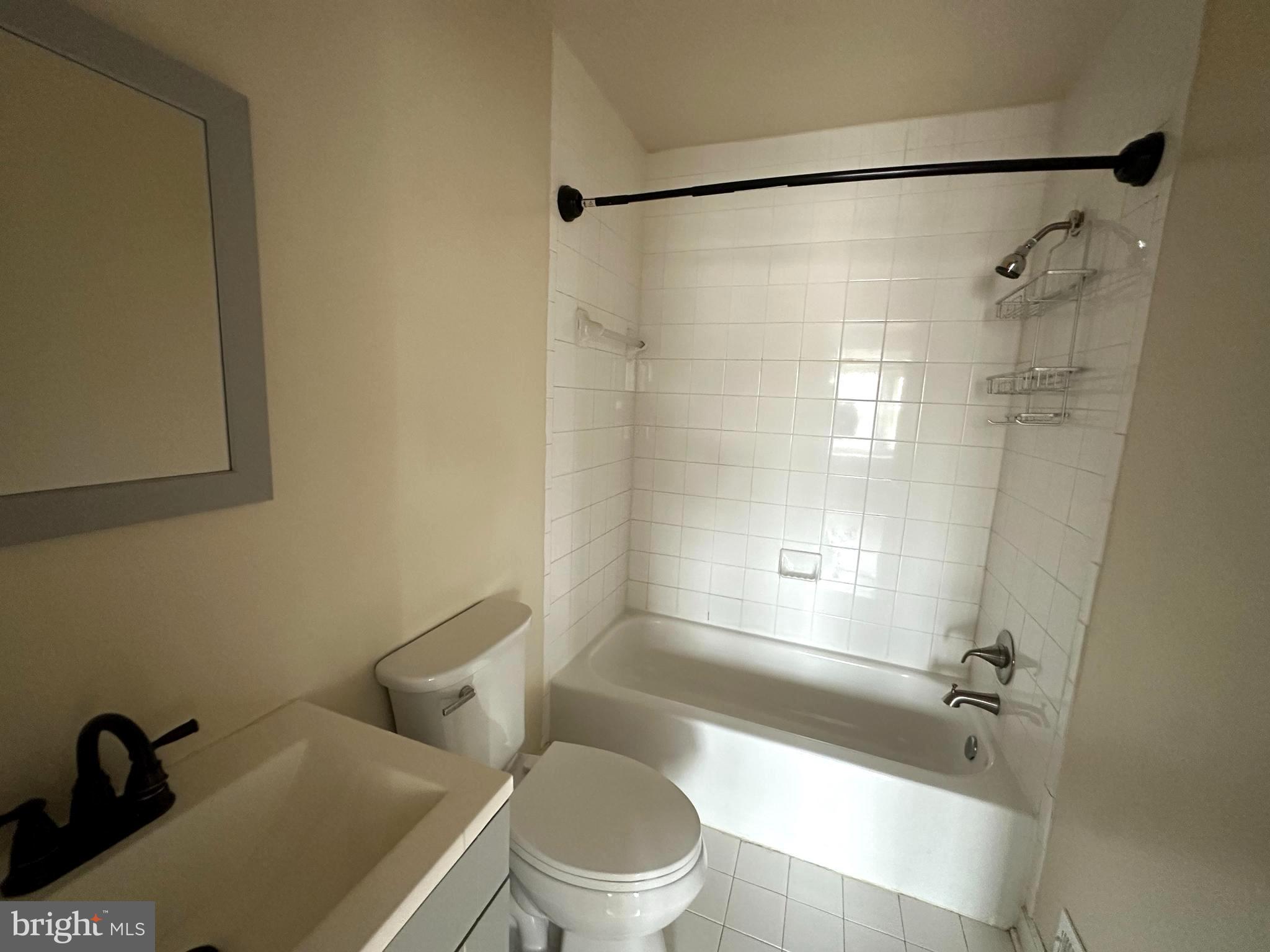 4033 Chesterwood Drive, Unit 4033 Silver Spring, MD 20906 - Photo 12 of 13 a white toilet sitting next to a bath tub shower