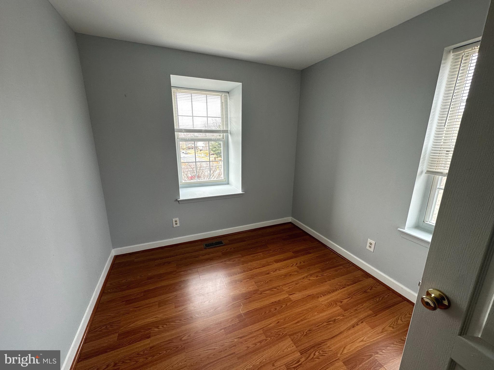4033 Chesterwood Drive, Unit 4033 Silver Spring, MD 20906 - Photo 9 of 13 an empty room with wooden floor and windows