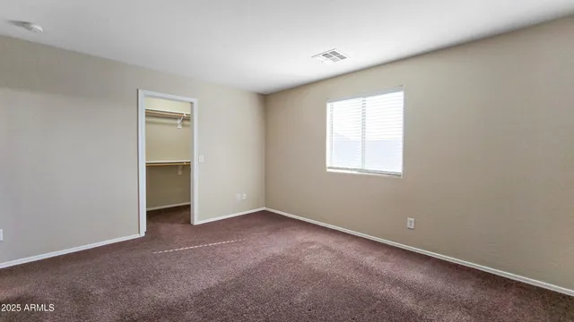 an empty room with a window and closet