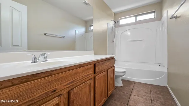 a bathroom with a granite countertop sink a toilet and bathtub
