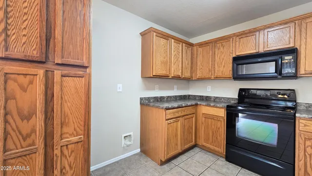 a kitchen with granite countertop wooden cabinets stainless steel appliances and a window