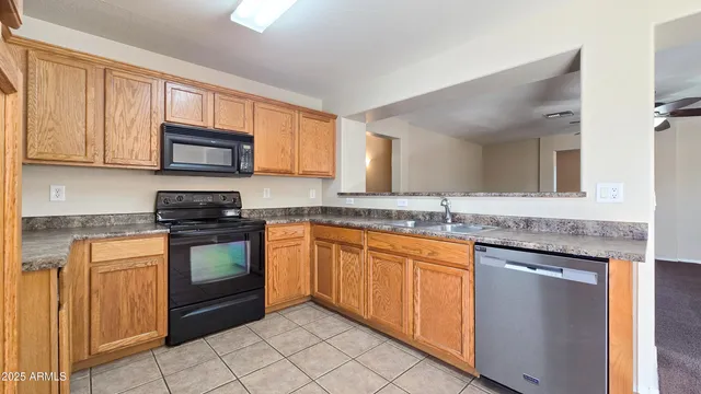 a kitchen with stainless steel appliances granite countertop a stove top oven a sink dishwasher and a microwave oven on the blue kitchen countertops