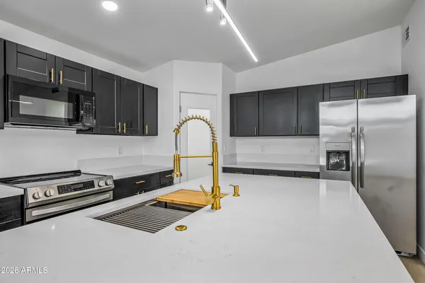 a kitchen with stainless steel appliances granite countertop a sink and a stove