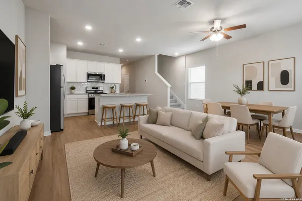 a living room with furniture kitchen view and a flat screen tv