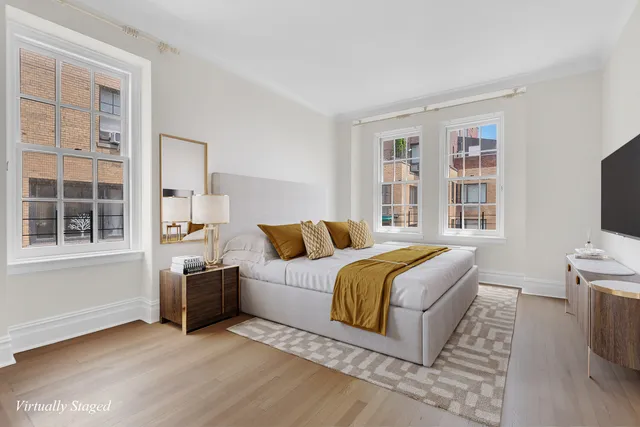 a living room with a bed furniture and a flat screen tv