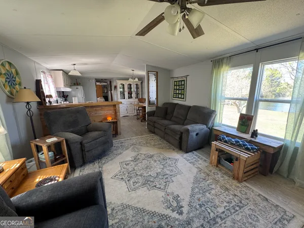 a living room with furniture a ceiling fan and a window