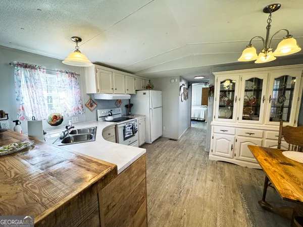 a kitchen with stainless steel appliances granite countertop sink stove top oven and cabinets