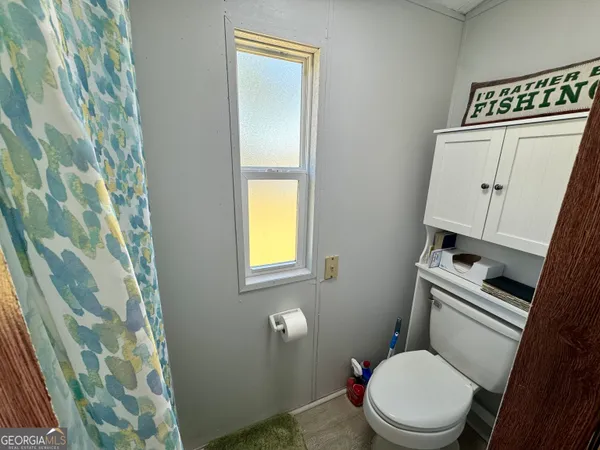 a white toilet sitting next to a shower curtain