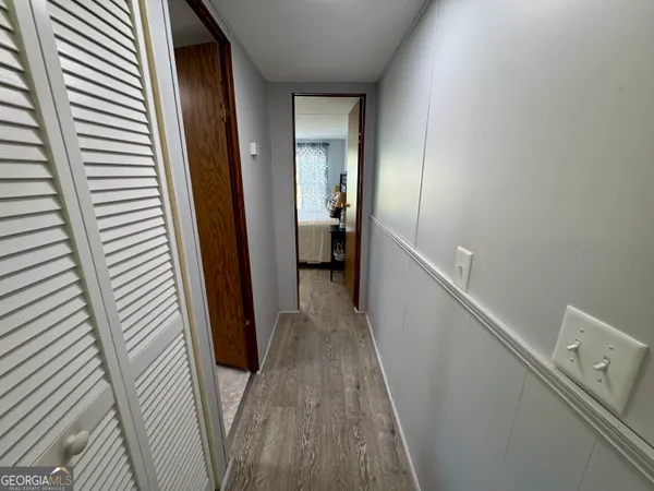 a view of a hallway with wooden floor and staircase