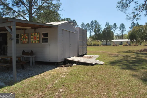 a view of a patio with chairs and table in the backyard
