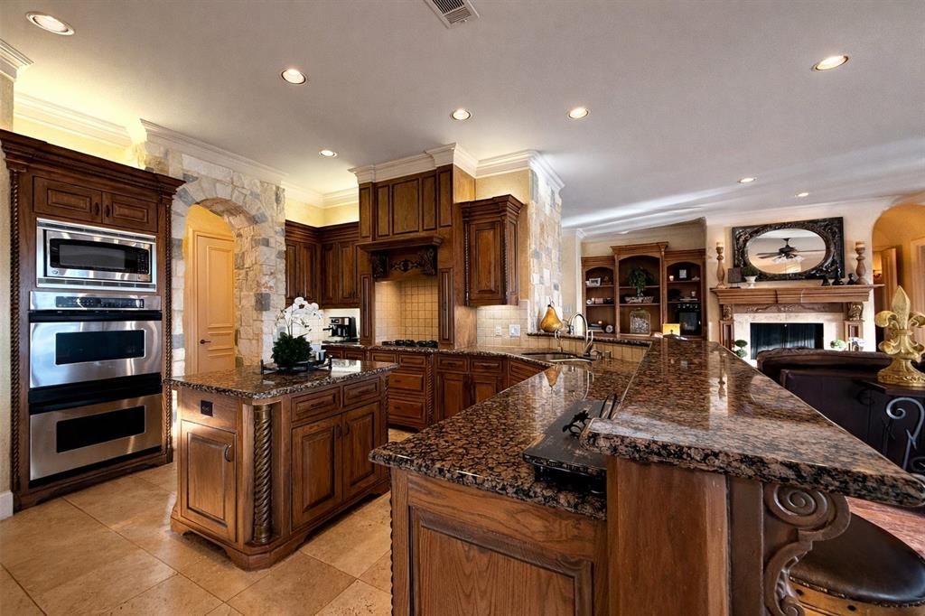 1919 Kings Pass Heath, TX 75032 - Photo 10 of 38 The kitchen features rich wood cabinetry, granite countertops, and stainless steel appliances including a built-in microwave and oven