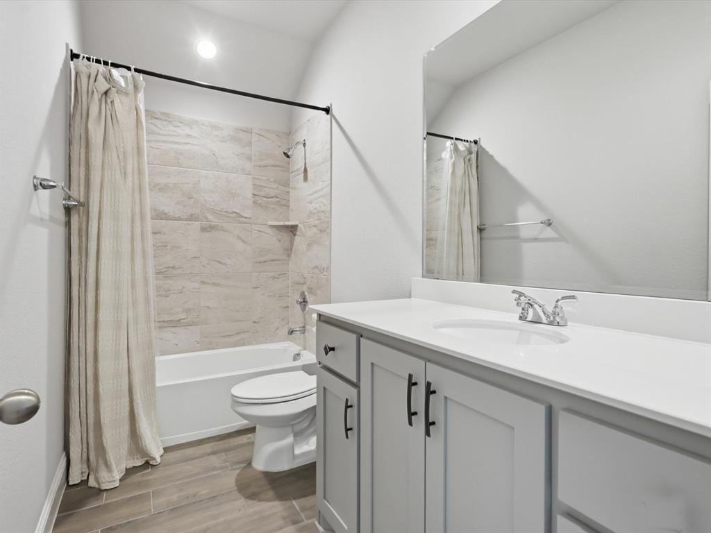 1601 Radecke Road Krum, TX 76249 - Photo 26 of 32 a bathroom with a sink a toilet and a large mirror