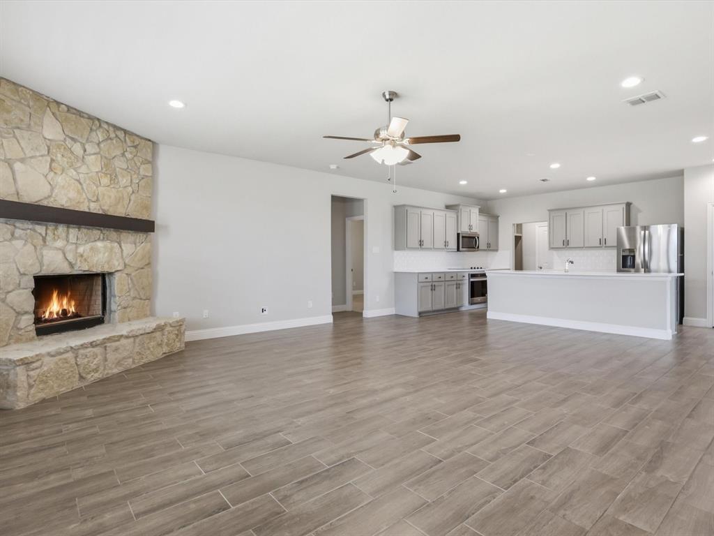1601 Radecke Road Krum, TX 76249 - Photo 5 of 32 a view of a living room a kitchen with a fireplace and chandelier