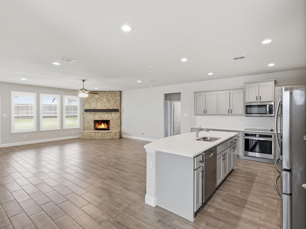 1601 Radecke Road Krum, TX 76249 - Photo 31 of 32 a kitchen with stainless steel appliances granite countertop a stove top oven a sink and a refrigerator