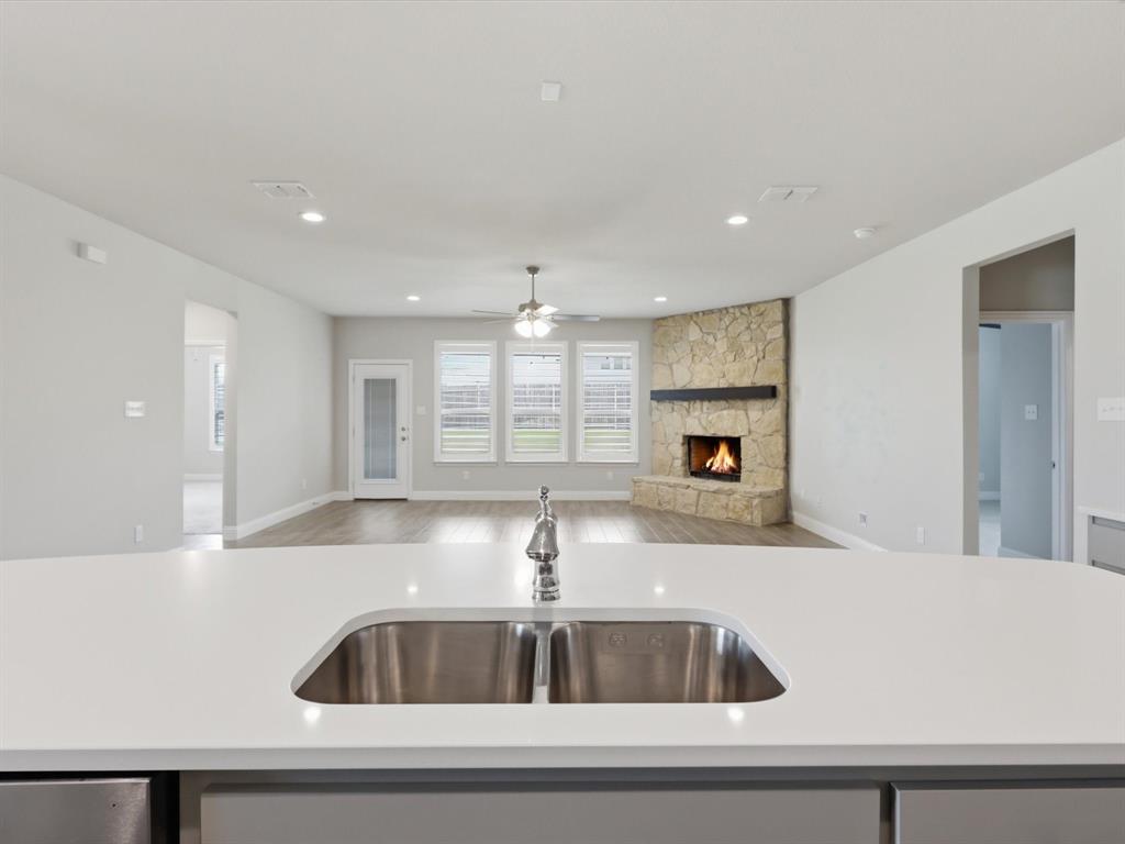1601 Radecke Road Krum, TX 76249 - Photo 6 of 32 a kitchen with kitchen island a sink and a stove with wooden floor