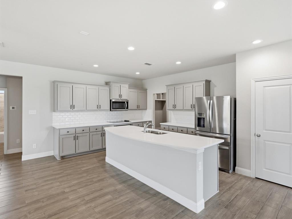 1601 Radecke Road Krum, TX 76249 - Photo 8 of 32 a kitchen with stainless steel appliances a refrigerator sink and microwave