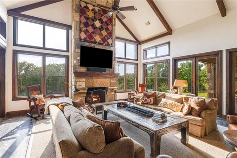 a living room with furniture a flat screen tv and a large window