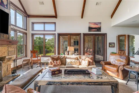 a living room with fireplace furniture and large window