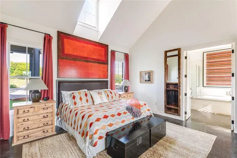 a bedroom with a bed a dresser next to a window