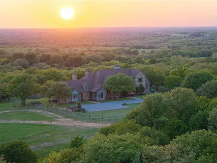 an aerial view of residential houses with outdoor space and trees