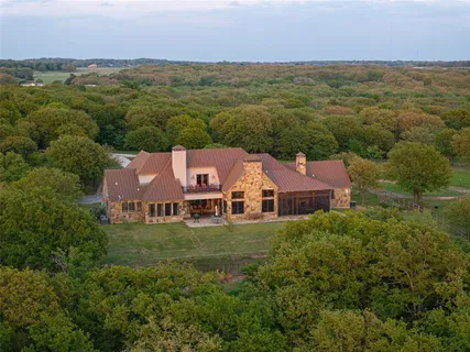 an aerial view of residential houses with outdoor space and trees