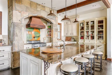 a kitchen with a table chairs stove and cabinets