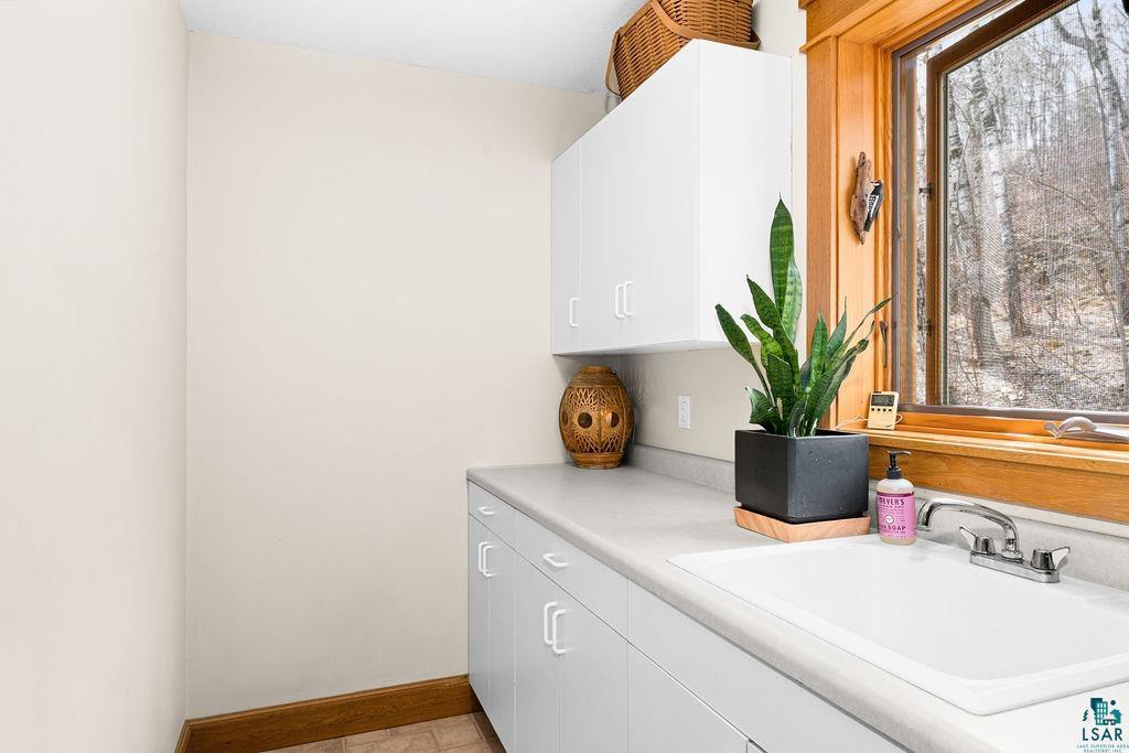4856 Kingston Street Duluth, MN 55804 - Photo 18 of 88 Utility sink with chrome faucet, light-toned countertop, and white cabinetry