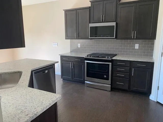a kitchen with granite countertop a stove and a microwave