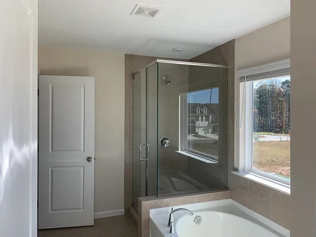 a bathroom with a tub shower and sink