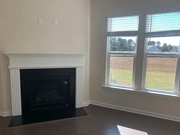 an empty room with windows and fireplace