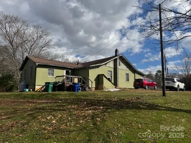 a view of a house with large trees and playing area