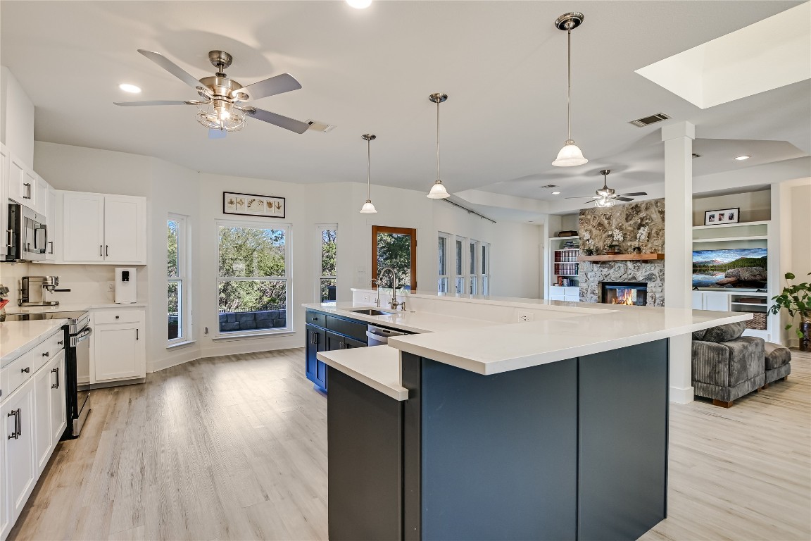 945 Wesley Ridge Drive Spicewood, TX 78669 - Photo 11 of 40 Extended kitchen sightlines reinforce the home’s open layout, allowing the space to function as both a working kitchen and a central gathering area.