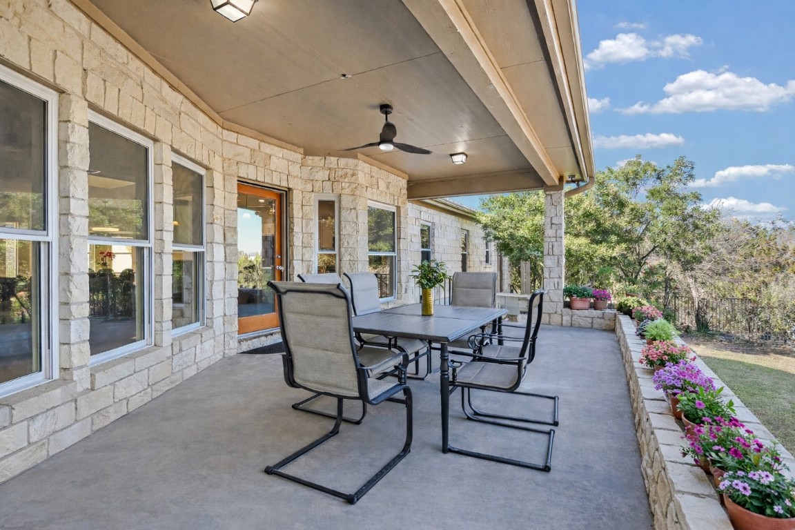 945 Wesley Ridge Drive Spicewood, TX 78669 - Photo 18 of 40 Covered back porch accessed from both the living area and study. (Photo has been virtually staged to reflect a spring landscape.)