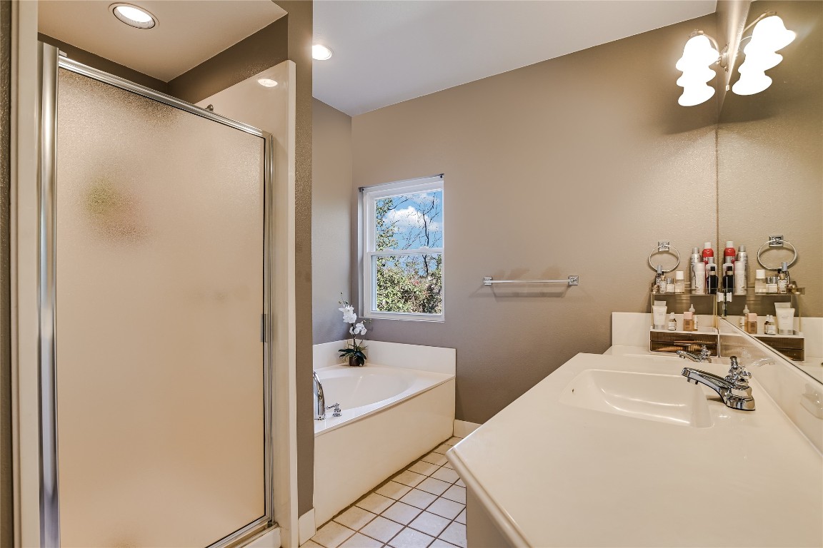 945 Wesley Ridge Drive Spicewood, TX 78669 - Photo 22 of 40 Primary bath featuring a separate soaking tub, walk-in shower, and dual vanity.