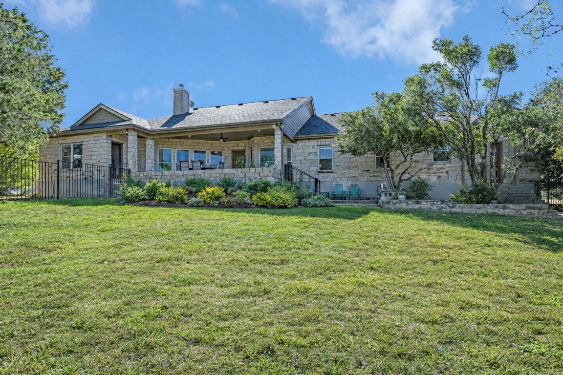 945 Wesley Ridge Drive Spicewood, TX 78669 - Photo 5 of 40 Generous backyard space with room to relax, play, or entertain, complemented by the home’s covered back porch. (Landscape digitally enhanced to reflect spring conditions.)