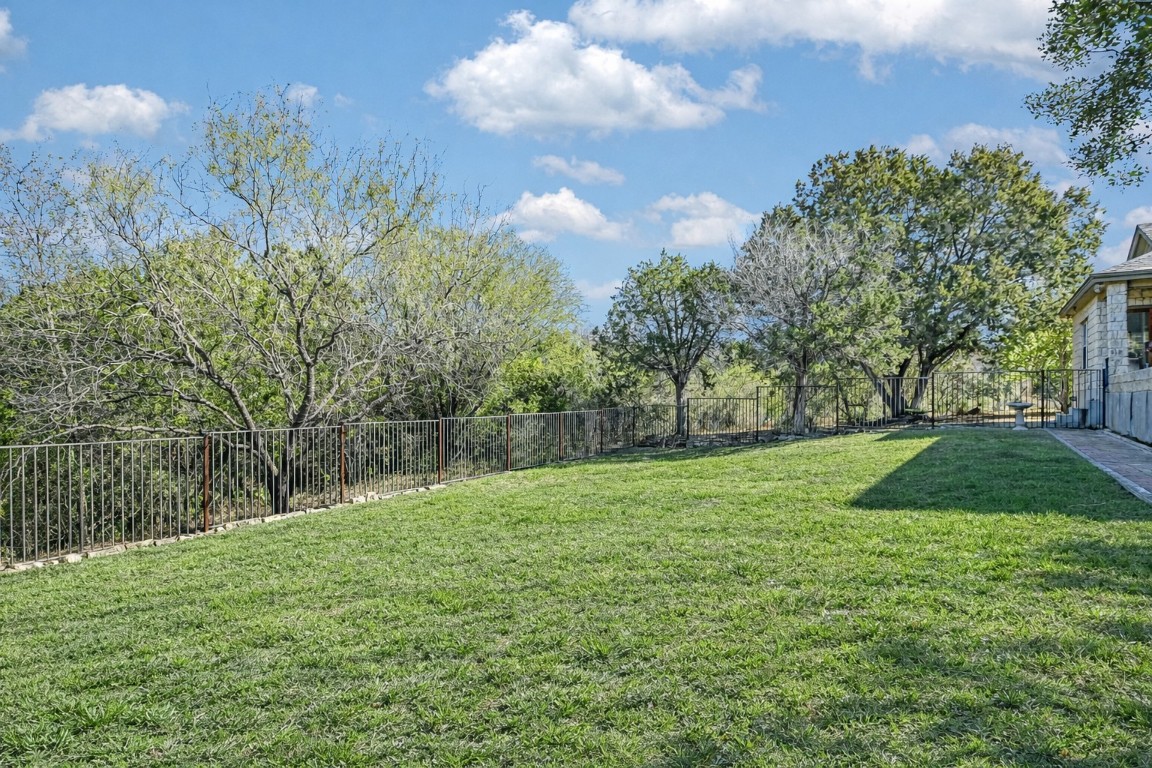 945 Wesley Ridge Drive Spicewood, TX 78669 - Photo 6 of 40 The fenced backyard offers level ground with flexibility for future outdoor enhancements or a pool. (Landscape has been digitally enhanced to reflect seasonal greenery.)